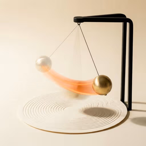 Read: a brass kinetic pendulum captured mid-swing over a topographic disc