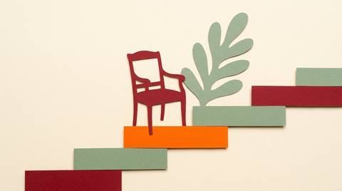 CMO tenure and the growth mandate: paper cutout of a chair on a rising stepped path, one step in bright orange.